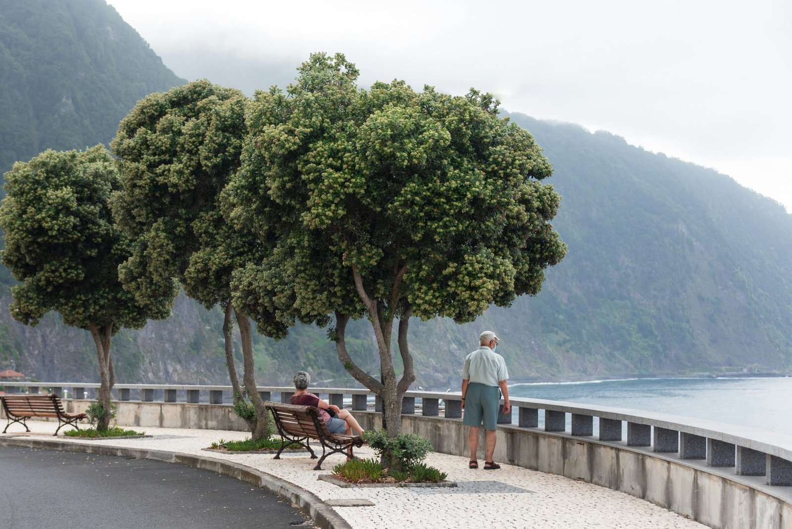 a couple of people sitting on top of a wooden bench